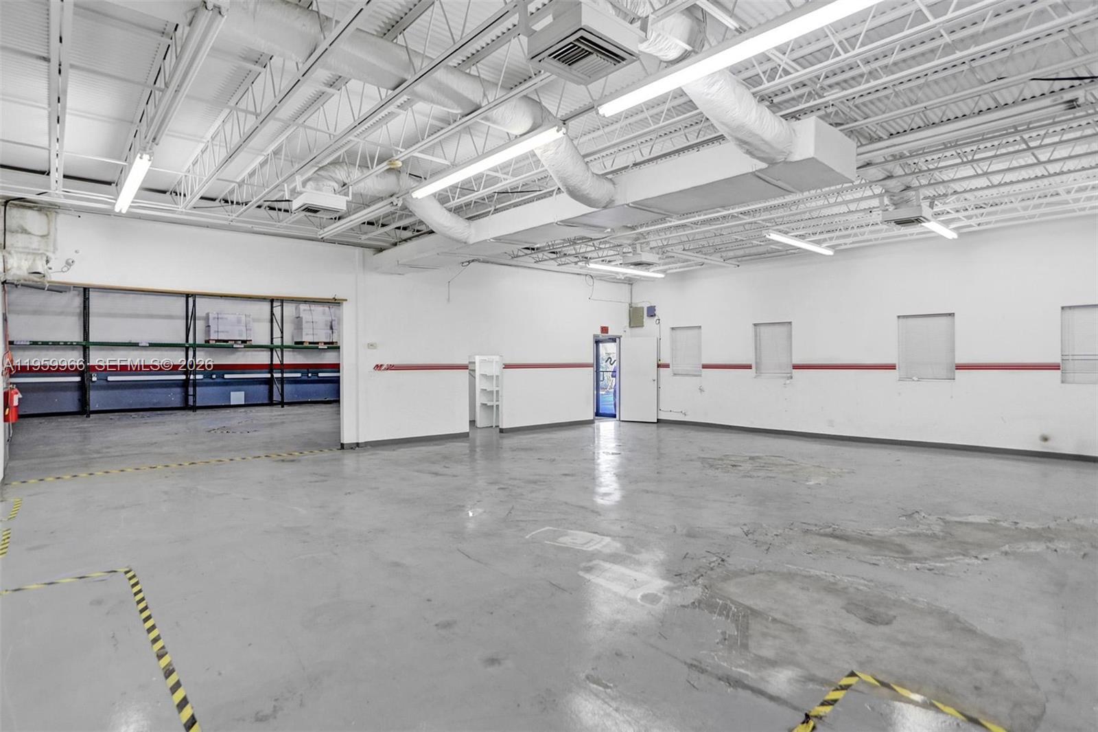 An industrial warehouse space features a concrete floor, exposed ceiling, and white walls — 1900 NW 32nd St, Pompano Beach FL 33064, POMPANO BEACH, FL