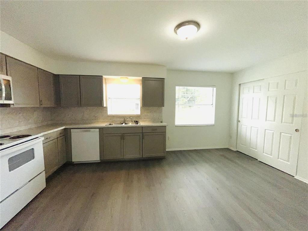 A kitchen with grey cabinets, white appliances, and light wood-look flooring — 1509 PHYLLIS STREET, LAKELAND, FL