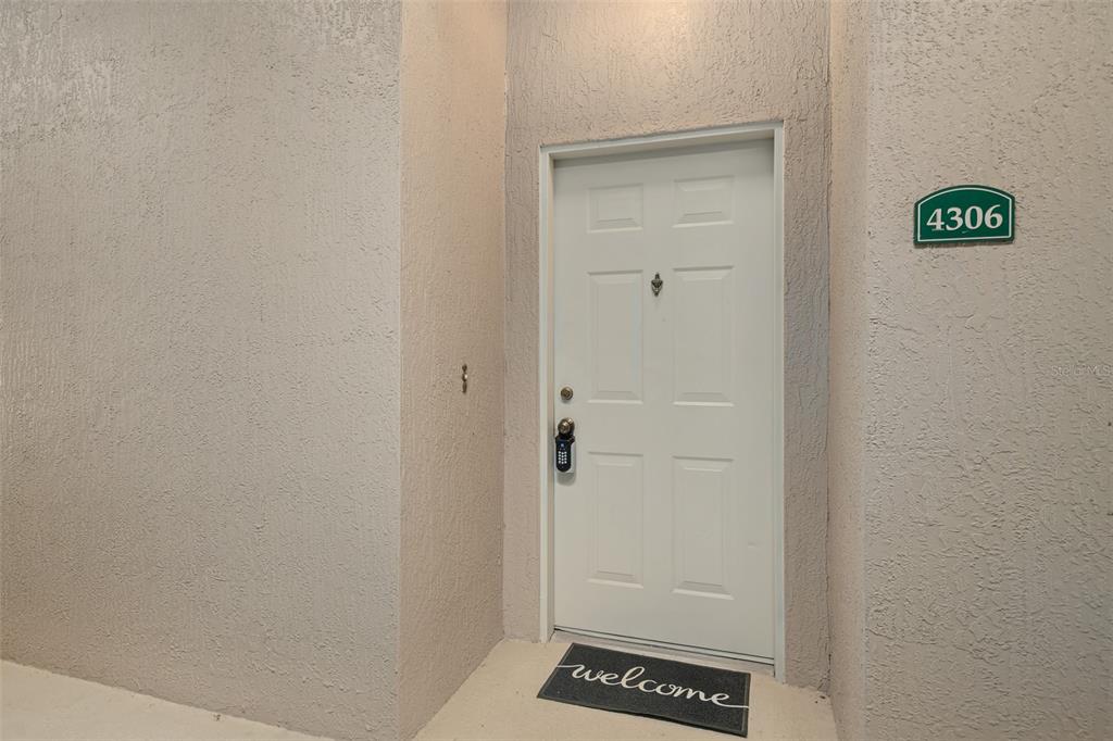 A kitchen features light wood cabinets, dark laminate countertops, and a white dishwasher — 4833 CYPRESS WOODS DRIVE UNIT 4306, ORLANDO, FL