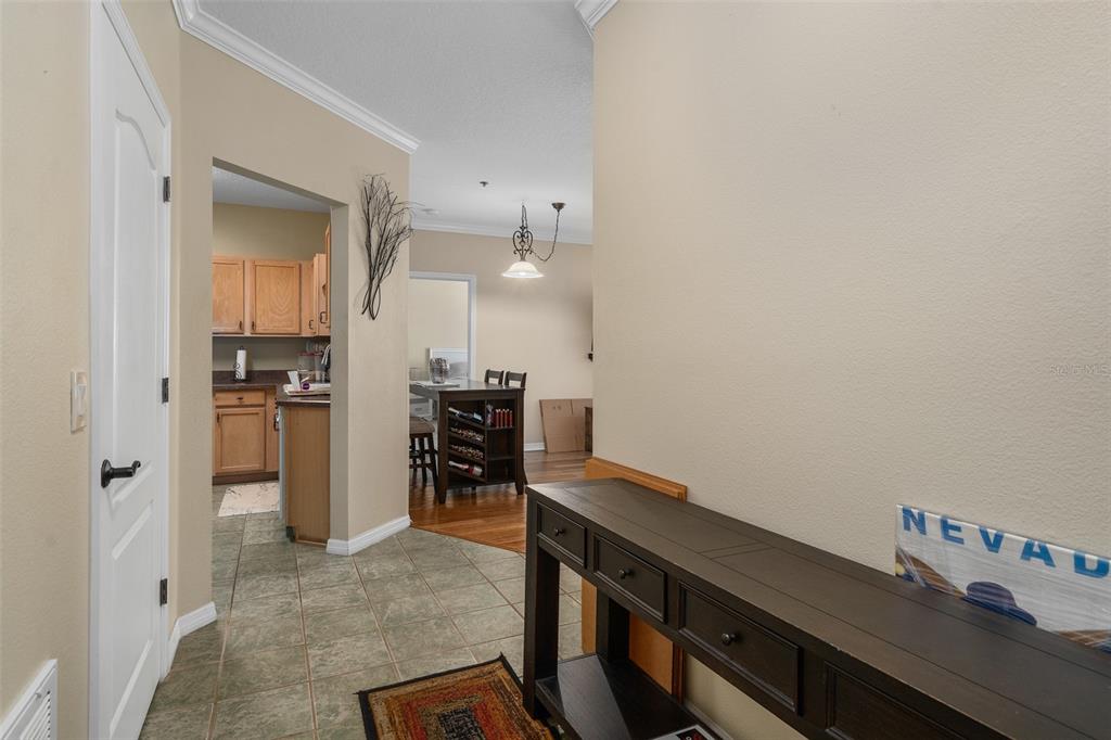 A kitchen features light wood cabinets, white appliances, dark countertops, and tile flooring — 4833 CYPRESS WOODS DRIVE UNIT 4306, ORLANDO, FL