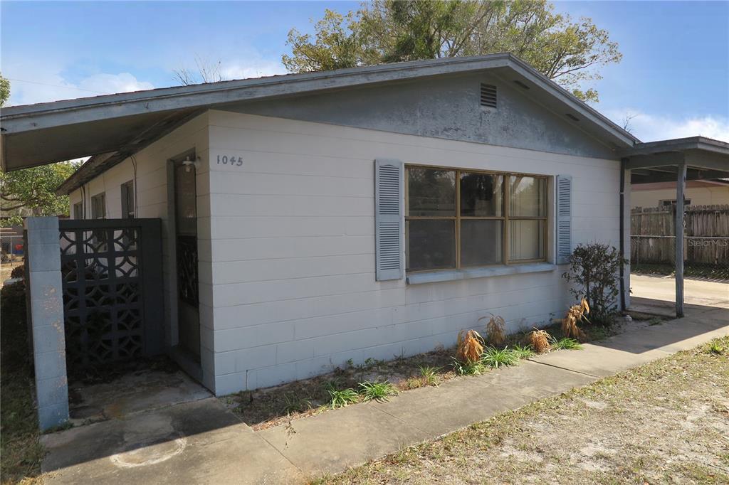 A single-story house with a concrete block exterior, a front window, and a carport — 1045 SE 19TH STREET, GAINESVILLE, FL