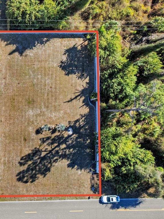 An aerial view shows a rectangular, cleared vacant lot bordered by trees and a road — 2306 CEDARWOOD STREET, PORT CHARLOTTE, FL