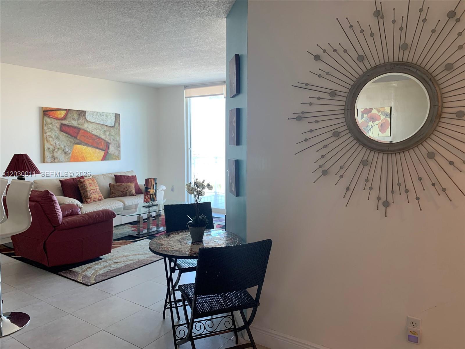 A dining area features a glass-topped table, four chairs, a small accent table, and wall art — 275 NE 18th # 1709, Miami FL 33132, MIAMI, FL
