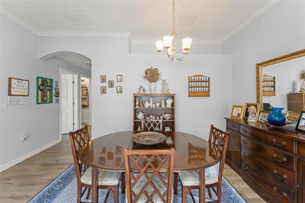 A dining room features a round wooden table, chairs, a hutch, and a sideboard — 674 SANDY NECK LANE UNIT 102, ALTAMONTE SPRINGS, FL