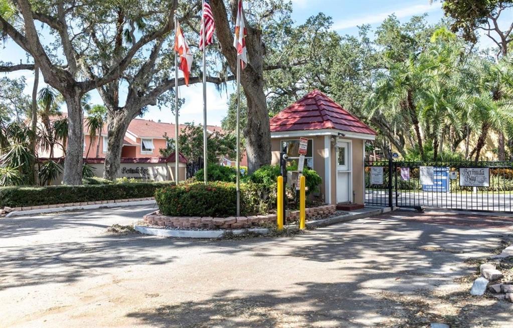 A living room with a large television, leather seating, a coffee table, and sliding glass doors — 4160 35TH TERRACE S UNIT I, ST PETERSBURG, FL