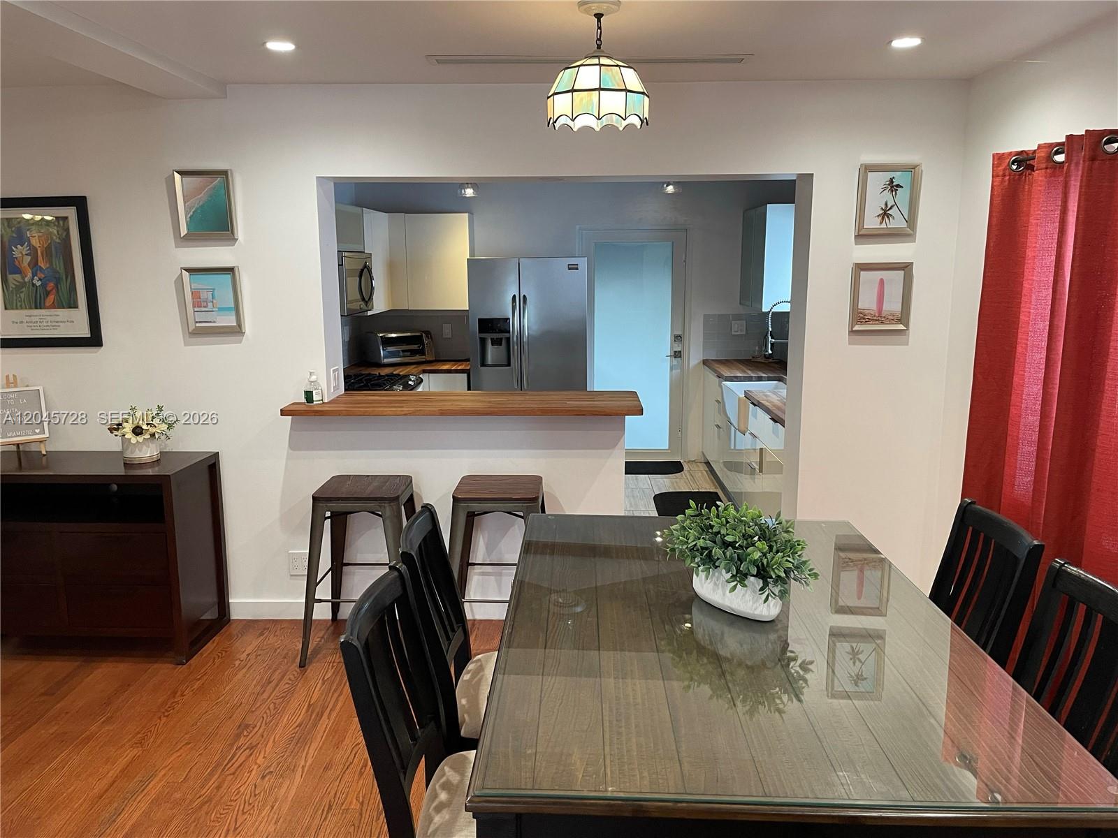 A modern kitchen features white cabinets, wood countertops, a farmhouse sink, and a wood ceiling — 2112 SW 60th Ct, Miami FL 33155, MIAMI, FL