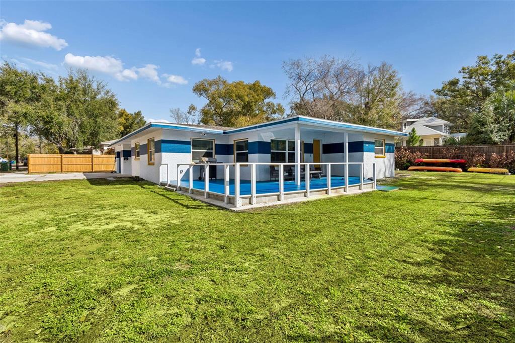 A single-story house with a blue and white exterior features a raised wooden deck — 1102 E RIVER COVE STREET, TAMPA, FL