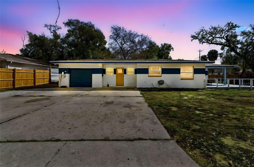 A single-story house with a white and blue exterior, a garage, and a concrete driveway — 1102 E RIVER COVE STREET, TAMPA, FL