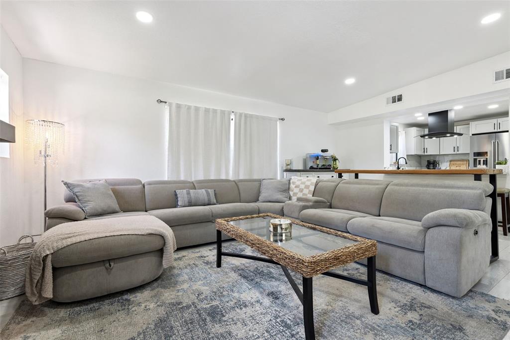 A living room features a large gray sectional sofa, a glass-topped coffee table, and kitchen — 1915 WEBER STREET, ORLANDO, FL