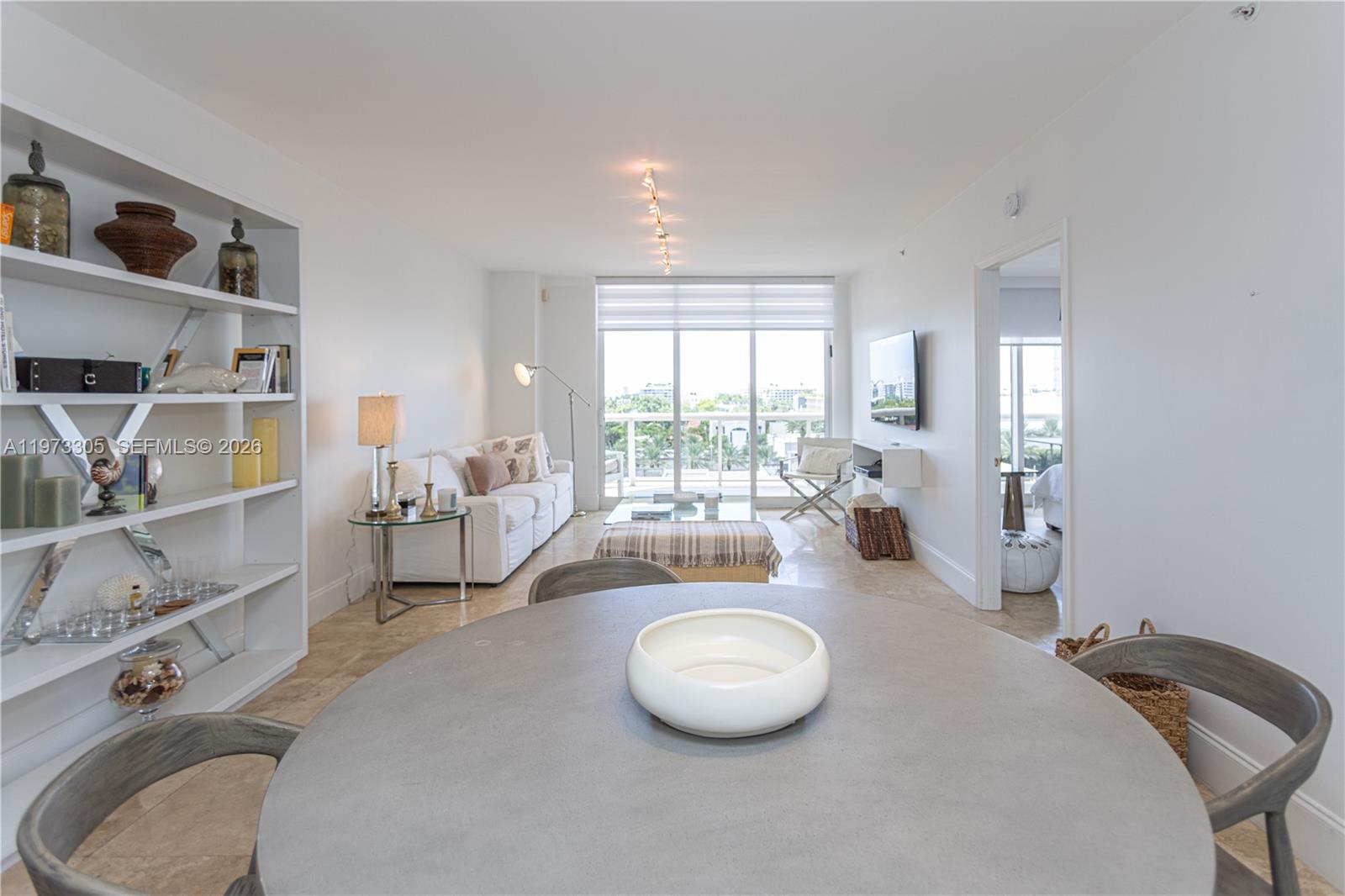 A bright living and dining area features white walls, tile floors, and a balcony view — 9595 Collins Ave # F, Surfside FL 33154, SURFSIDE, FL