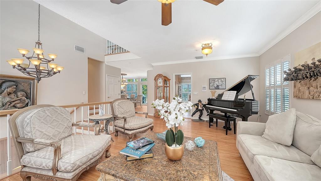 A living room features a grand piano, two armchairs, a sofa, and a chandelier — 3040 GULF OF MEXICO DRIVE UNIT 3, LONGBOAT KEY, FL