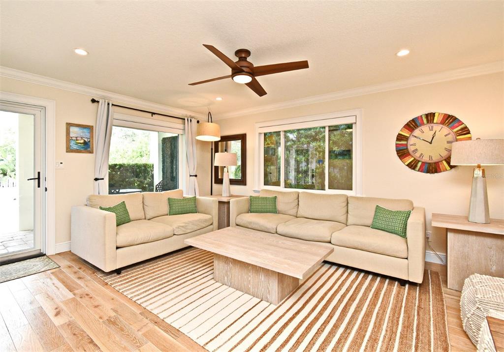 A living room features two beige sofas, a wooden coffee table, and a striped rug — 507 N PENINSULA AVENUE, NEW SMYRNA BEACH, FL