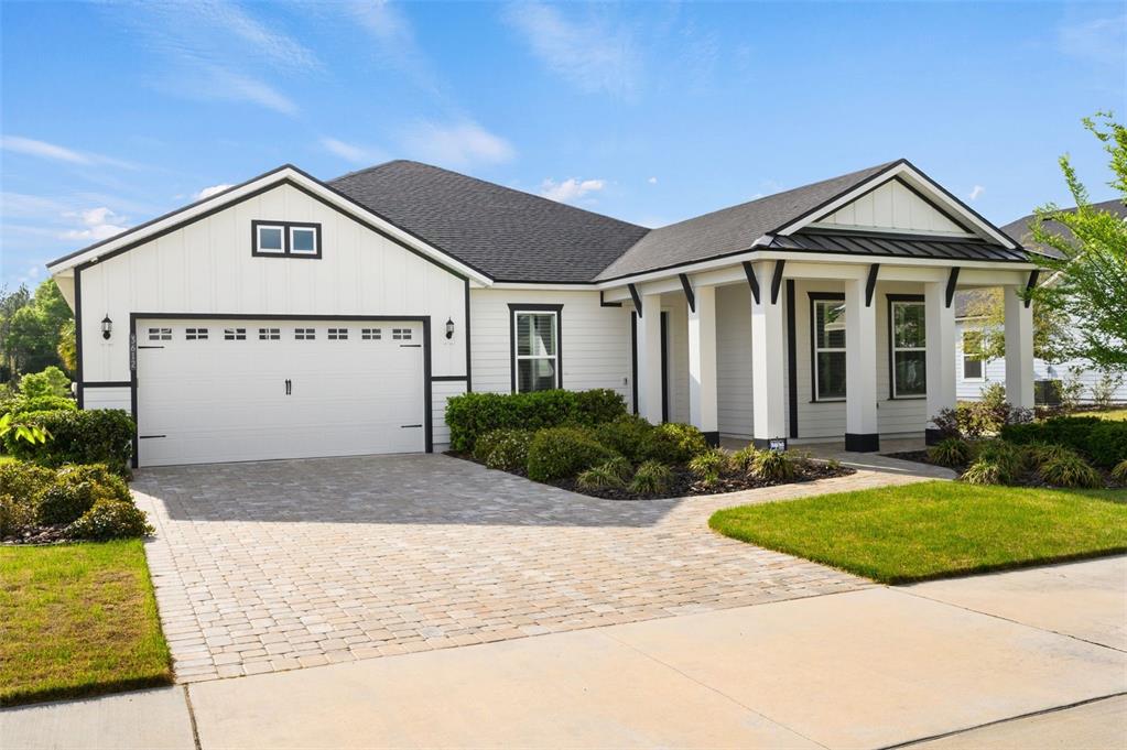 A single-story house with white siding, a two-car garage, and a covered front porch — 3612 SW 120TH TERRACE, GAINESVILLE, FL