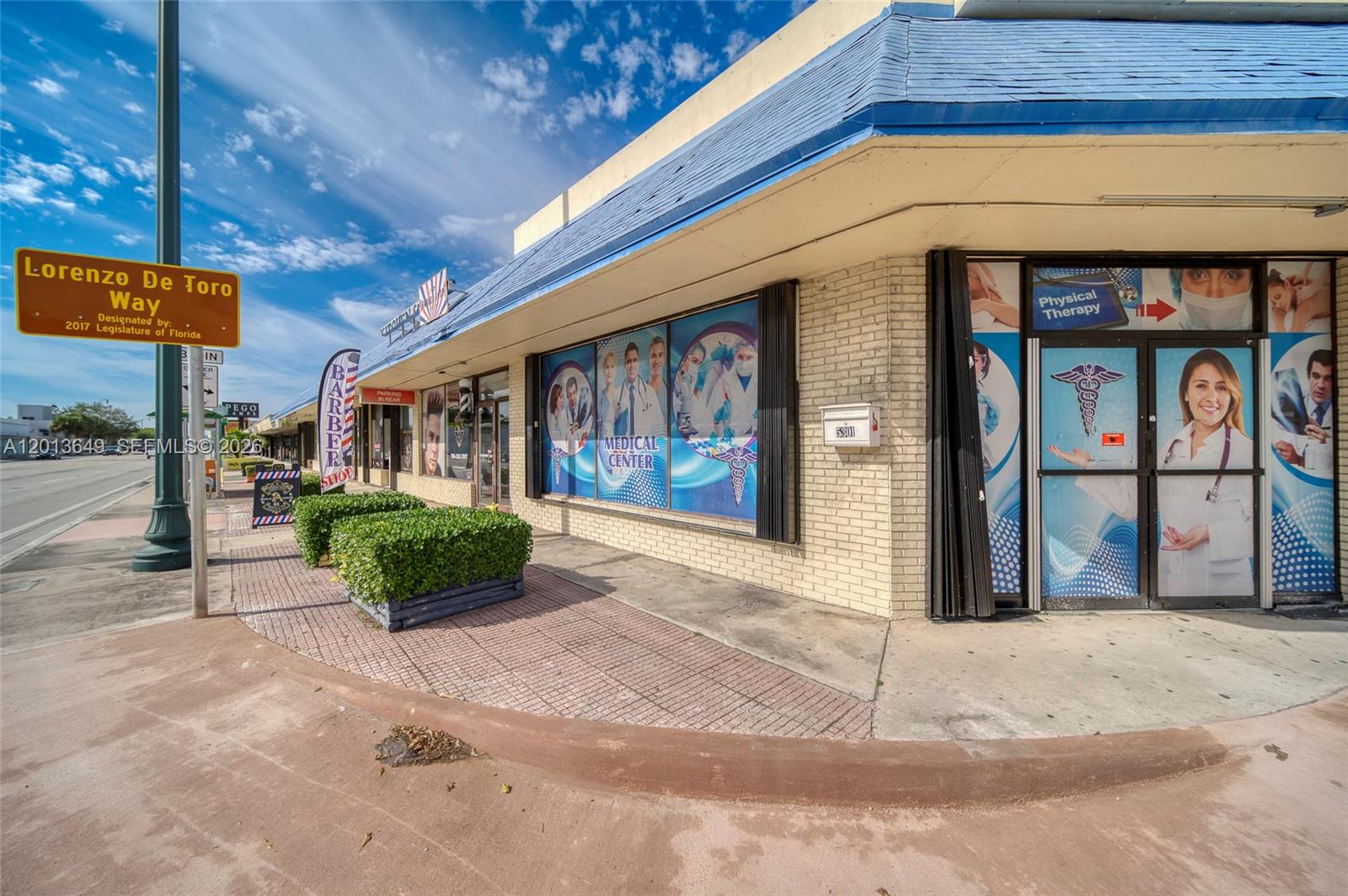 The exterior of a commercial strip mall features a medical center and a barber shop — 5301 SW 8th St, Miami FL 33134, MIAMI, FL