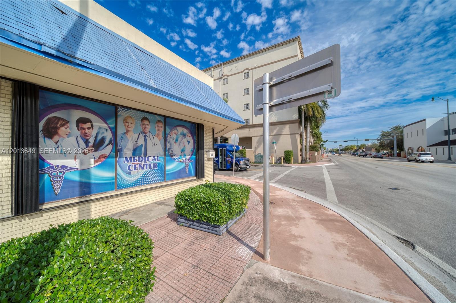 The exterior of a medical center building features blue awnings and large window advertisements — 5301 SW 8th St, Miami FL 33134, MIAMI, FL