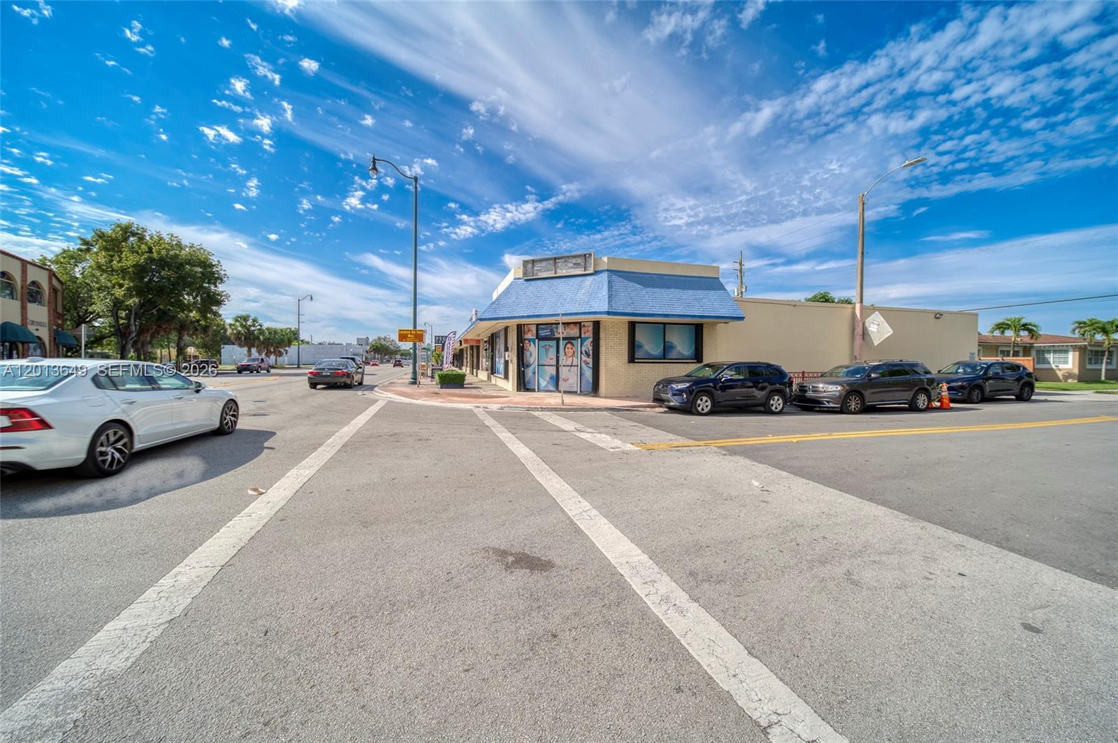 A commercial building with a blue roof sits on a corner lot near a street — 5301 SW 8th St, Miami FL 33134, MIAMI, FL