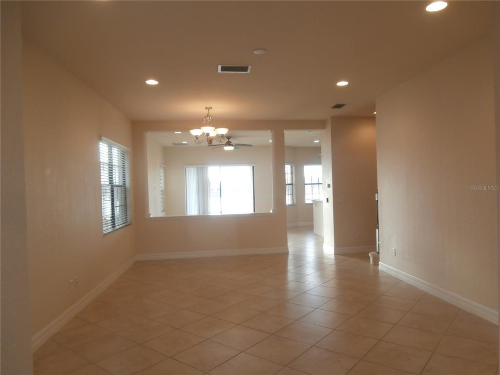 An open-concept living area features light-colored tile flooring, recessed lighting, and a chandelier — 13172 WOODFORD STREET, ORLANDO, FL