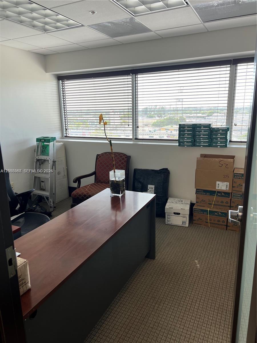 An office with a desk, a chair, a ladder, and stacked boxes by the windows — 7480 SW 40th St # 750, Miami FL 33155, MIAMI, FL