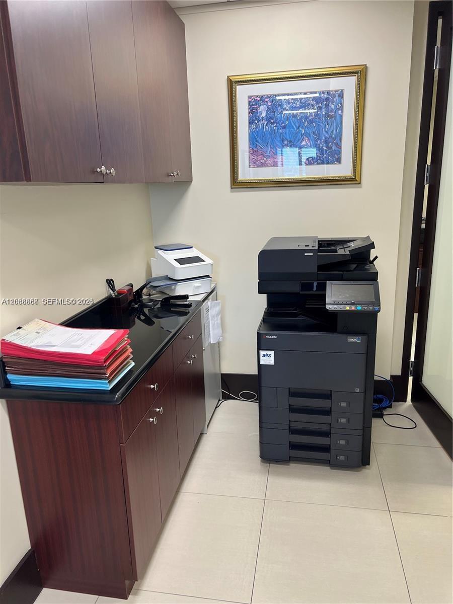 A small office space features dark wood cabinetry, a black countertop, and a large printer — 7480 SW 40th St # 750, Miami FL 33155, MIAMI, FL