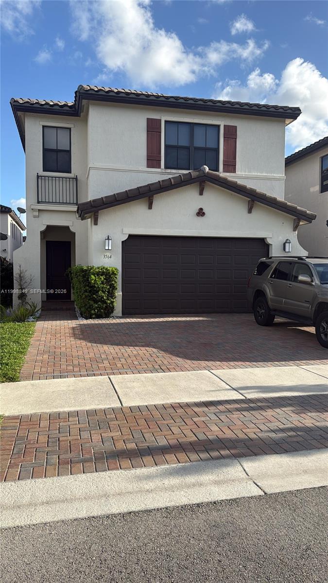 A two-story stucco house features a brown tiled roof, a garage, and a brick driveway — 3564 W 97th St, Hialeah FL 33018, HIALEAH, FL