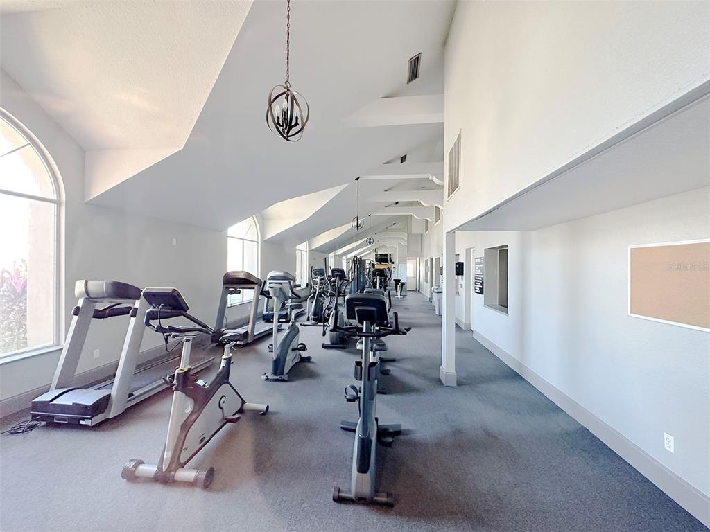 A fitness center features multiple treadmills and stationary bikes on a carpeted floor — 5124 CONROY ROAD UNIT 12, ORLANDO, FL
