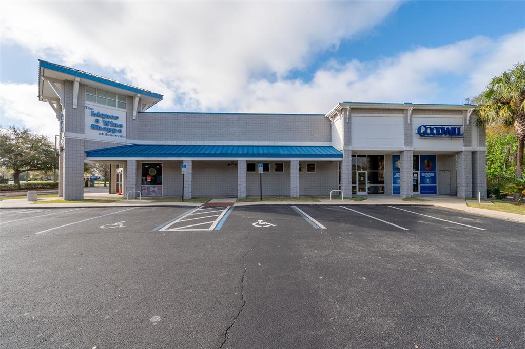A commercial building exterior features a liquor store and a Goodwill storefront with parking — 14451 W NEWBERRY ROAD, NEWBERRY, FL