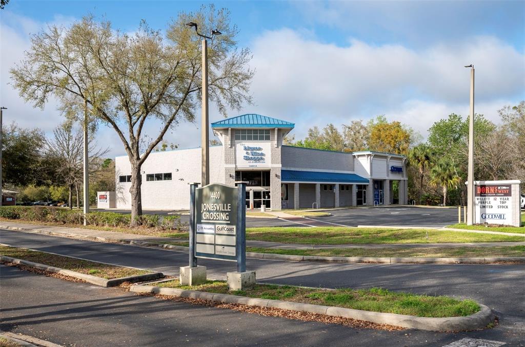 A commercial building with a blue roof stands behind a Jonesville Crossing sign — 14451 W NEWBERRY ROAD, NEWBERRY, FL