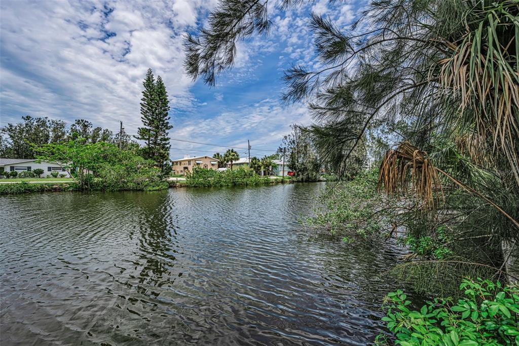 A view of a canal with houses in the background and trees in the foreground — Lot 15 RICE ROAD, HUDSON, FL