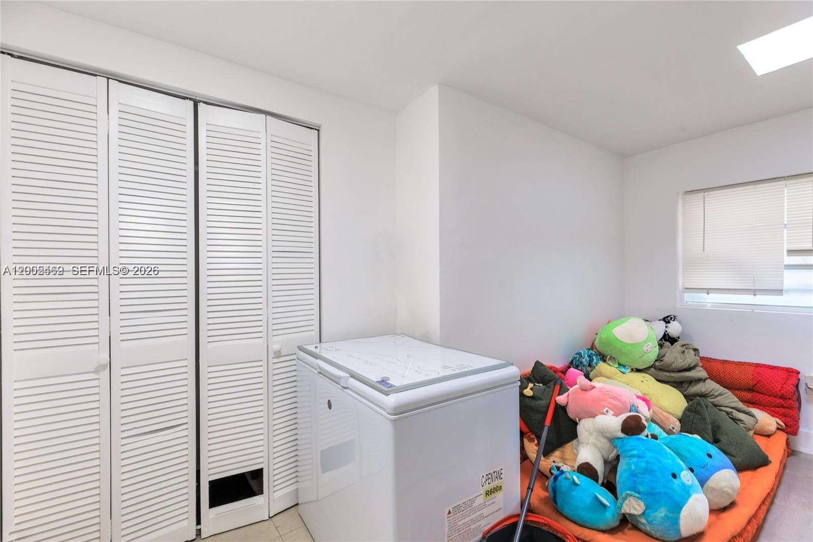 A room features white louvered closet doors, a chest freezer, and a pile of plush toys — 14601 NW 10th Ave # 2, Miami FL 33168, MIAMI, FL