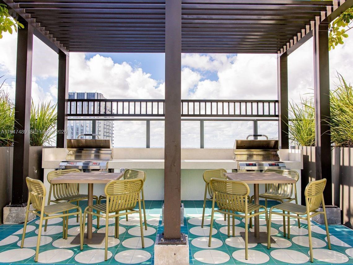 An outdoor rooftop patio features two stainless steel grills, dining tables, and patterned tile flooring — 11 NE 6 ST # 814, Miami FL 33132, MIAMI, FL