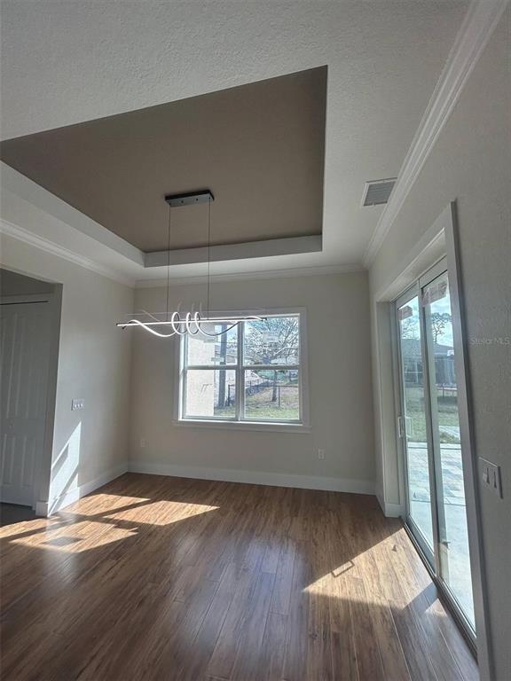 A modern kitchen features white cabinetry, a granite-topped island, and a chevron-patterned tile backsplash — 1126 ARREDONDO STREET, NORTH PORT, FL