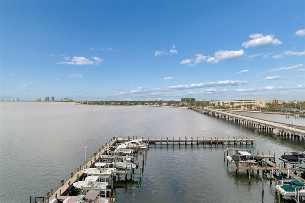 A high-angle view shows a boat dock with several vessels extending into a large bay — 2 ADALIA AVENUE UNIT 704, TAMPA, FL