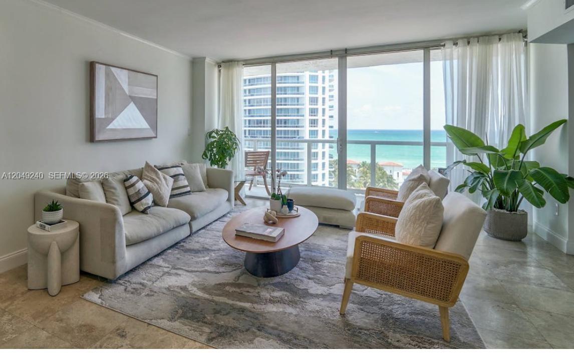 A living room features a beige sofa, two rattan chairs, and floor-to-ceiling windows overlooking ocean — 5900 Collins Ave # 1406, Miami Beach FL 33140, MIAMI BEACH, FL