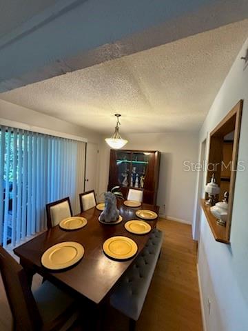 A dining room features a wooden table with gold chargers, a bench, and a china cabinet — 4846 PEBBLE BEACH UNIT 1010B, ORLANDO, FL
