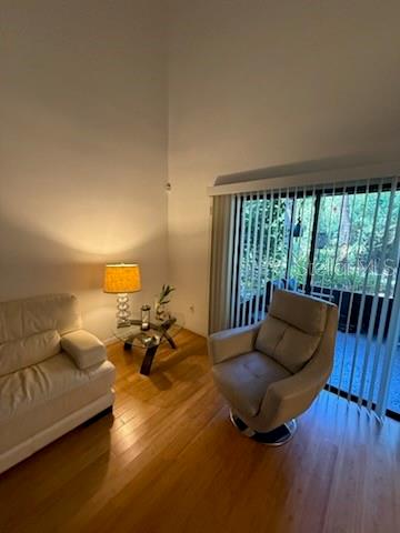 A living room features a white sofa, a swivel chair, and a lamp on a table — 4846 PEBBLE BEACH UNIT 1010B, ORLANDO, FL