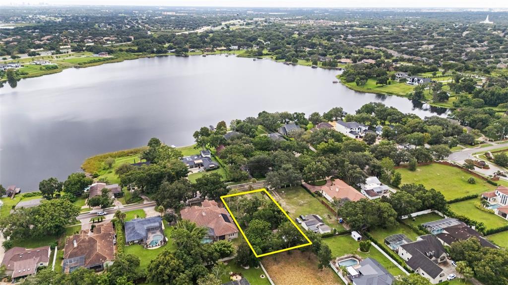 An aerial view shows a rectangular vacant lot outlined in yellow within a residential neighborhood — 1516 HEMPEL AVENUE, WINDERMERE, FL