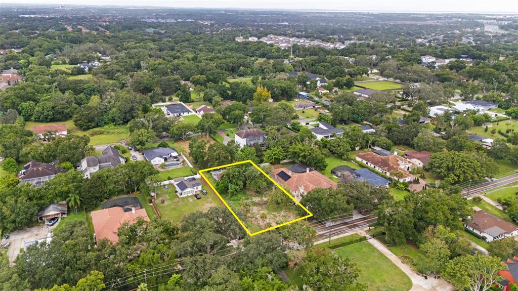 An aerial view shows a vacant, rectangular residential lot outlined in yellow among surrounding houses — 1516 HEMPEL AVENUE, WINDERMERE, FL