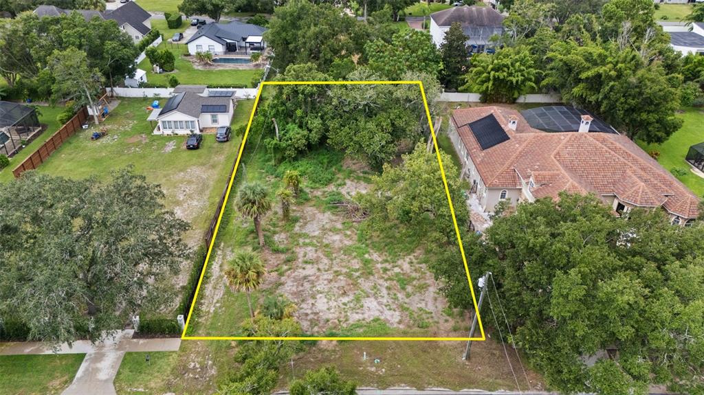 An aerial view shows a vacant, rectangular lot outlined in yellow between two residential properties — 1516 HEMPEL AVENUE, WINDERMERE, FL
