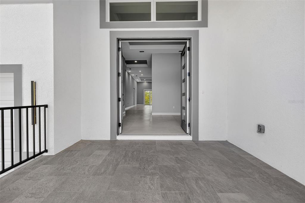 A view from a tiled porch looking through an open doorway into a modern interior — 15109 AQUARIUS CIRCLE, PORT CHARLOTTE, FL
