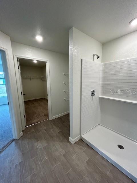 A tiled walk-in shower stands next to an open doorway leading into a carpeted closet — 7354 ELLIS LANE, PORT CHARLOTTE, FL