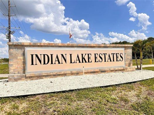 A stone monument sign displays the words Indian Lake Estates against a blue sky — 906 GRANADA DRIVE, INDIAN LAKE ESTATES, FL
