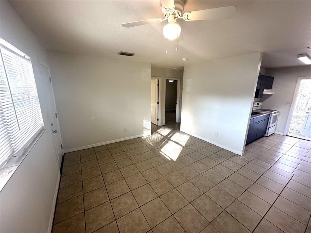 A tiled dining area features a ceiling fan and an adjacent kitchen with dark cabinets — 9601 N 10TH STREET UNIT B, TAMPA, FL
