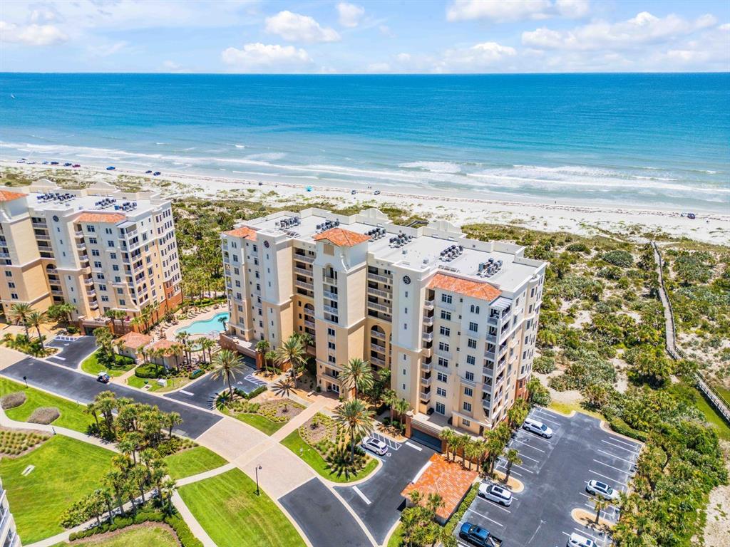 An aerial view of a multi-story beachfront resort complex with a pool and parking lot — 253 MINORCA BEACH WAY UNIT 604, NEW SMYRNA BEACH, FL