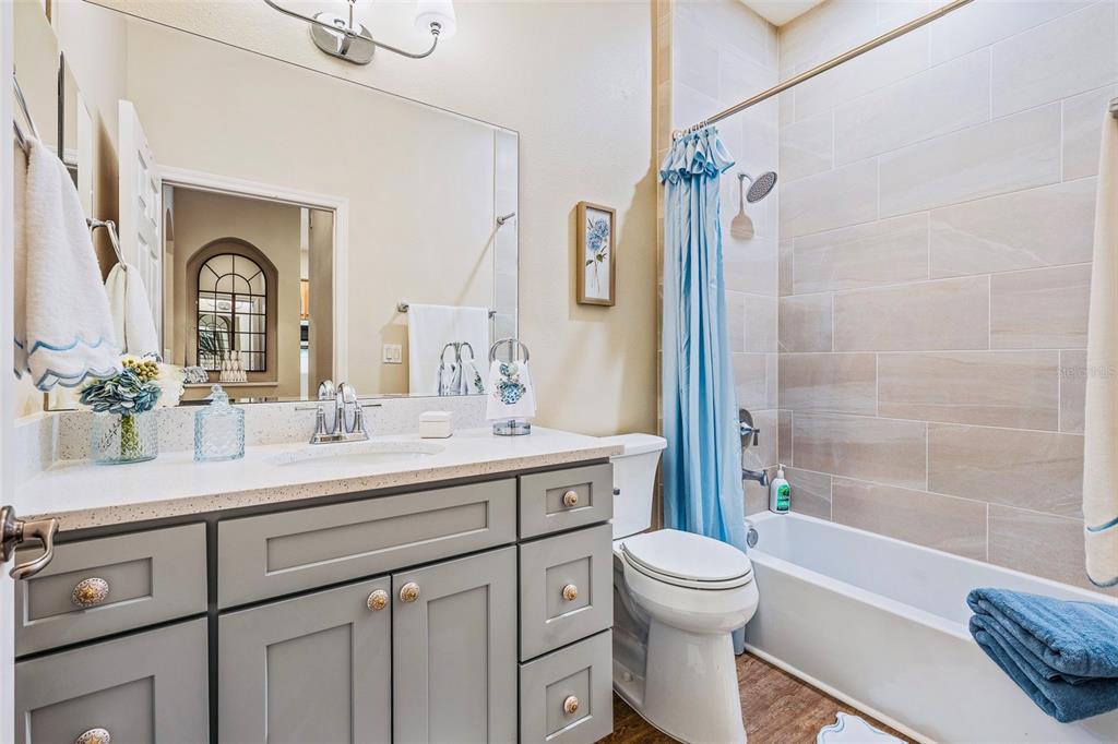 A bathroom features a gray vanity, a toilet, and a shower-tub combo with tiled walls — 15 OCEAN CREST WAY UNIT 1312, PALM COAST, FL