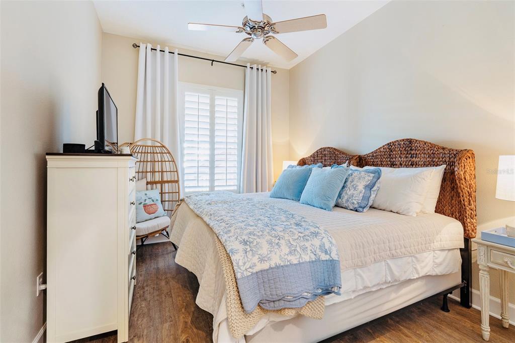 A bedroom features a wicker headboard, a white dresser, and a hanging chair by the window — 15 OCEAN CREST WAY UNIT 1312, PALM COAST, FL