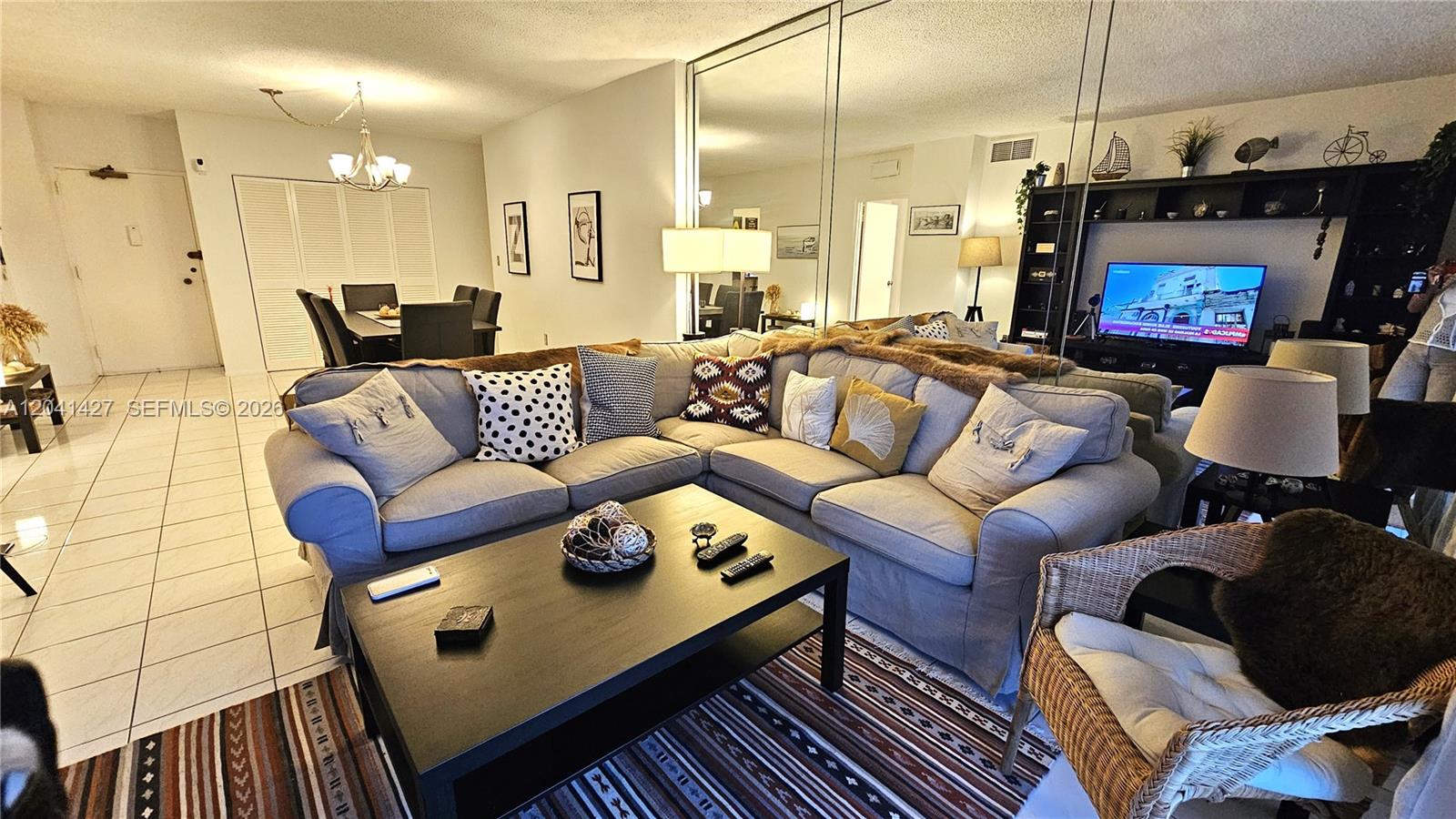 A living room features a large sectional sofa, a coffee table, and a mirrored wall — 1980 S Ocean Dr # 6B, Hallandale Beach FL 33009, HALLANDALE BEACH, FL