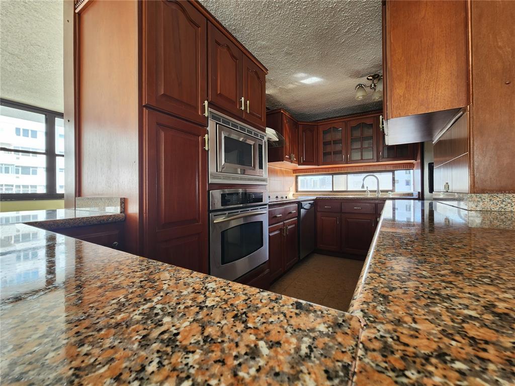 A kitchen features wood cabinets, granite countertops, and stainless steel appliances — Condado 8-18 C-MANUEL RODRIGUEZ SERRA UNIT 7B, SAN JUAN, PR
