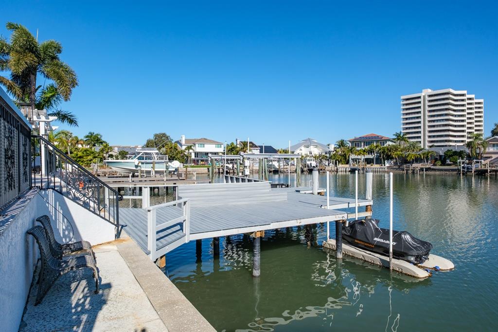 A wooden dock with a jet ski lift extends into a canal near waterfront homes — 5949 SEABIRD DRIVE S, GULFPORT, FL