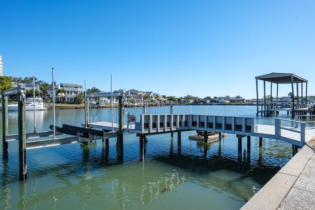 A wooden boat dock with a lift extends into a canal lined with residential homes — 5949 SEABIRD DRIVE S, GULFPORT, FL