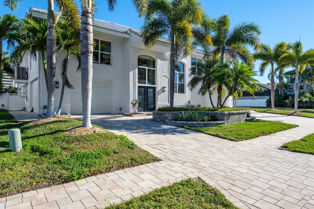 A two-story white house with a paved driveway, palm trees, and a stone planter — 5949 SEABIRD DRIVE S, GULFPORT, FL